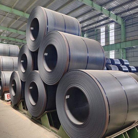 Unpackaged hot rolled steel coils stacked in an industrial warehouse